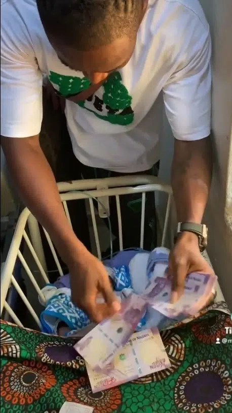 “This is senseless, so unhealthy for a new born”- Reactions as MC Noni showers 100 naira notes on his newborn